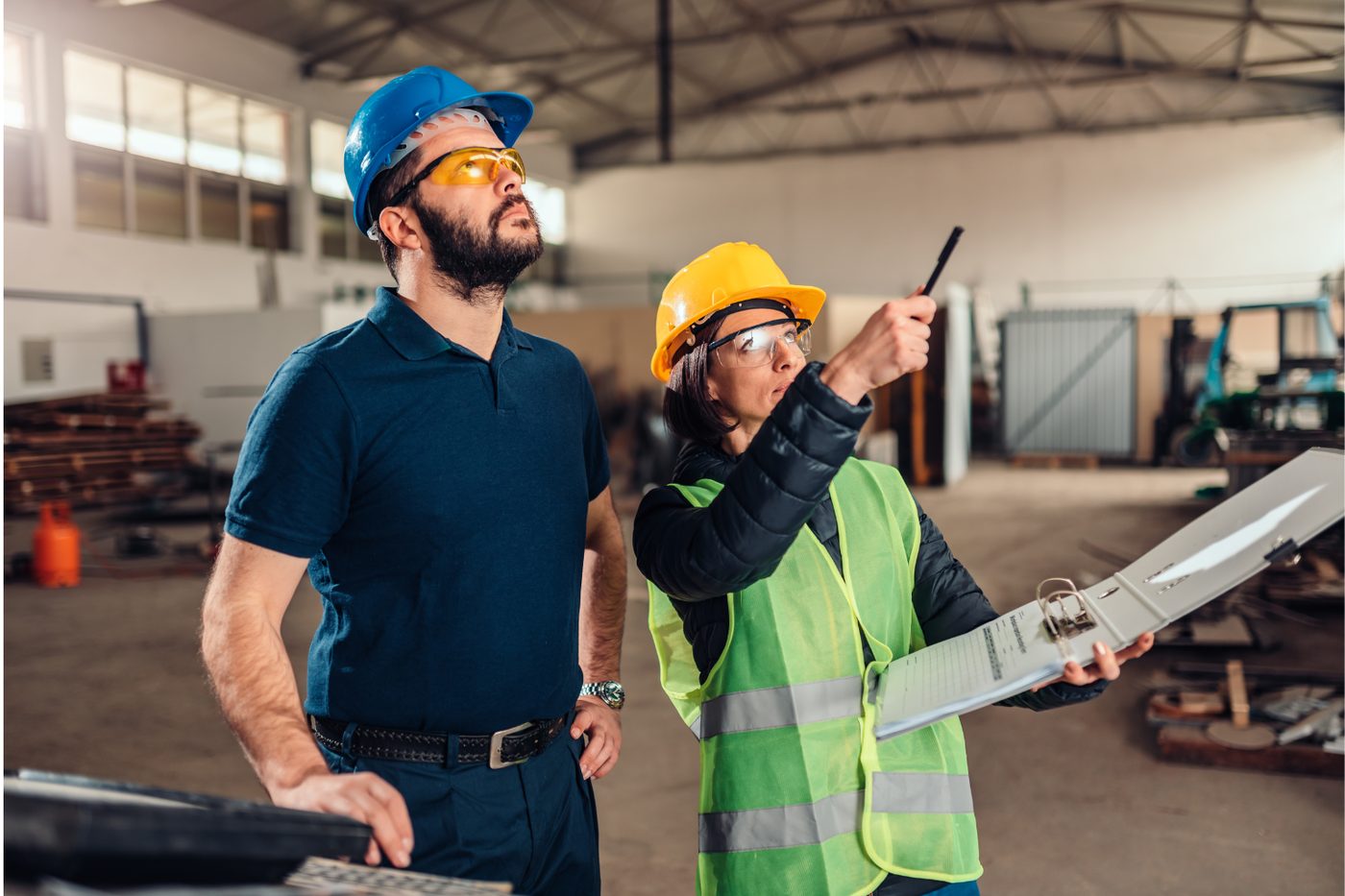 Dos supervisores con casco revisan un protocolo de inspección en obra